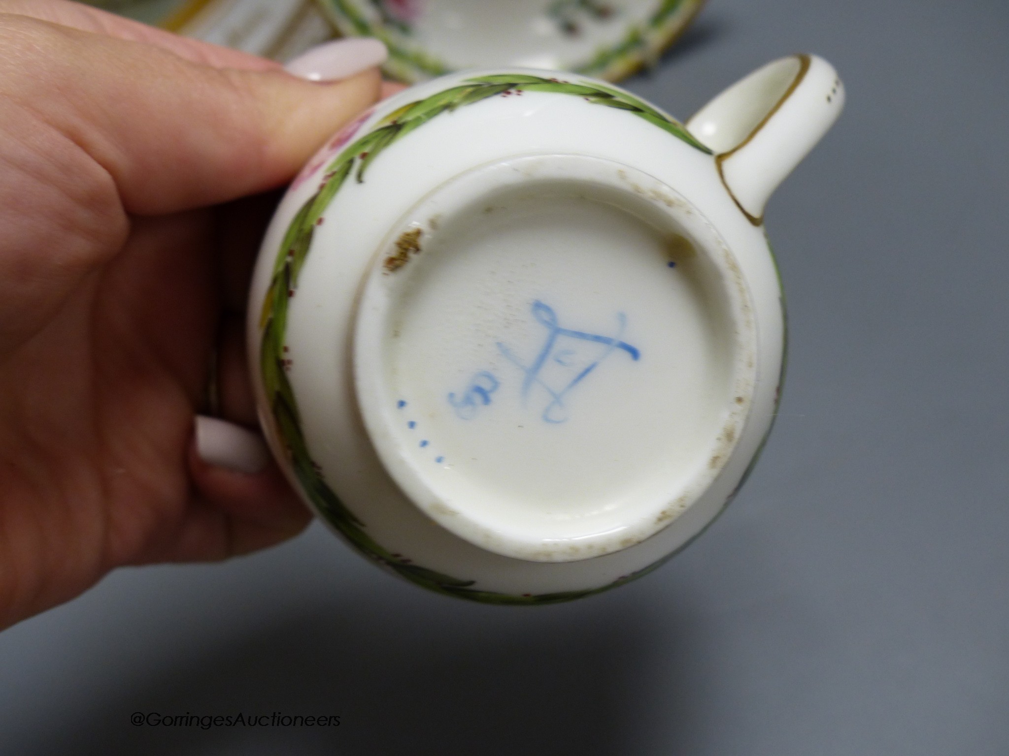 A Sevres porcelain coffee cup and saucer painted with flowers and chains of husks, and a paris porcelain plate with titled scene and initials TH